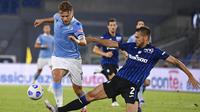 Striker Lazio, Ciro Immobile, berusaha melewati pemain Atalanta, Rafael Toloi, pada laga Liga Italia di Stadion Olimpico, Roma, Rabu (30/9/2020). Atalanta menang dengan skor 4-1. (Alfredo Falcone/LaPresse via AP)