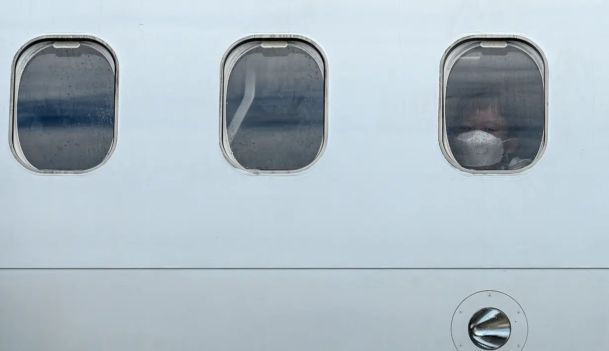 Seorang anak laki-laki melihat ke luar jendela pesawat Malaysia Airlines Boeing 738 setelah mendarat di Langkawi dari Bandara Internasional Kuala Lumpu (16/9/2021). Pulau liburan dibuka kembali untuk turis domestik setelah penutupan karena pembatasan Covid-19. (AFP/Mohd Rasfan)