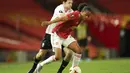 Gelandang Manchester United, Tahith Chong membawa bola dari kawalan pemain LASK, Thomas Sabitzer pada pertandingan leg kedua babak 16 besar Liga Europa di Stadion Old Trafford, Inggris (6/8/2020). MU menang 2-1 atas Lask dan melaju ke perempat final.  (AP Photo/Dave Thompson)