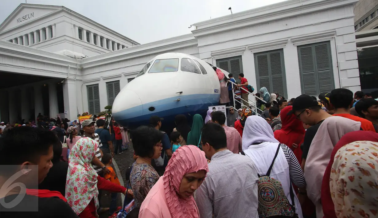 Pengunjung antre untuk masuk ke Pesawat N250 pada Habibie Festival di Museum Nasional, Jakarta, Minggu (14/8). Tingginya antusiasme warga membuat pengunjung harus antre untuk dapat melihat bagian dalam kendaraan tersebut. (Liputan6.com/Immanuel Antonius)
