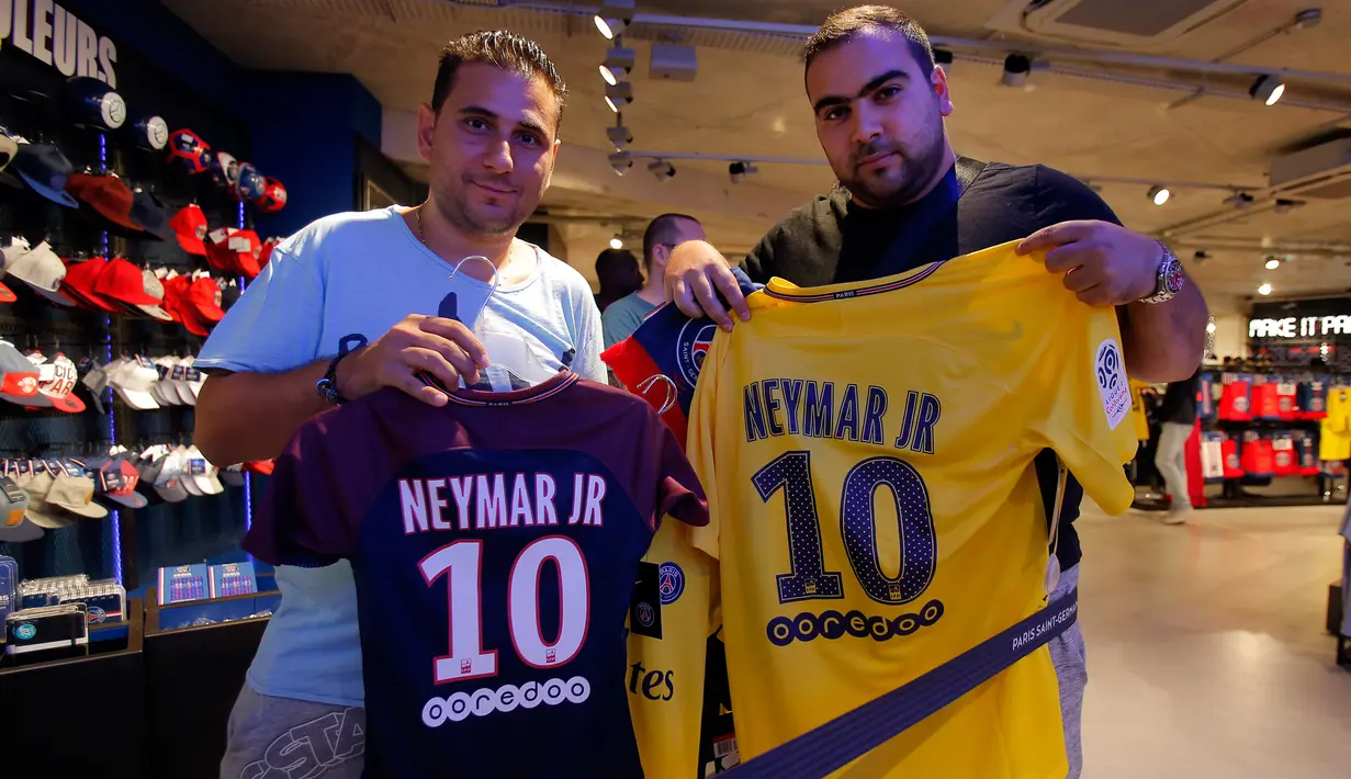 Suporter PSG menunjukkan jersey penyerang Neymar Jr di toko Paris Saint Germain di Paris (4/8). PSG resmi membeli Neymar dari Barcelona setelah menebus klausul pelepasan kontrak senilai 222 juta Euro, atau sekitar Rp 3,5 triliun. (AP Photo/Michel Euler)