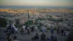 Orang-orang duduk di sudut pandang panorama kota Barcelona, Spanyol, Senin (21/10/2021). Barcelona adalah sebuah kota terbesar kedua di Spanyol dan merupakan ibu kota wilayah otonom Katalonia. (AP Photo/Joan Mateu)