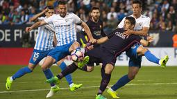 Pemain FC Barcelona, Luis Alberto Suarez (tengah) berebut bola dengan para pemain Malaga pada lanjutan La Liga Spanyol di di Estadio La Rosaleda (8/4/2017). Barcelona kalah 0-2 dari Malaga. (AP/Daniel Tejedor)