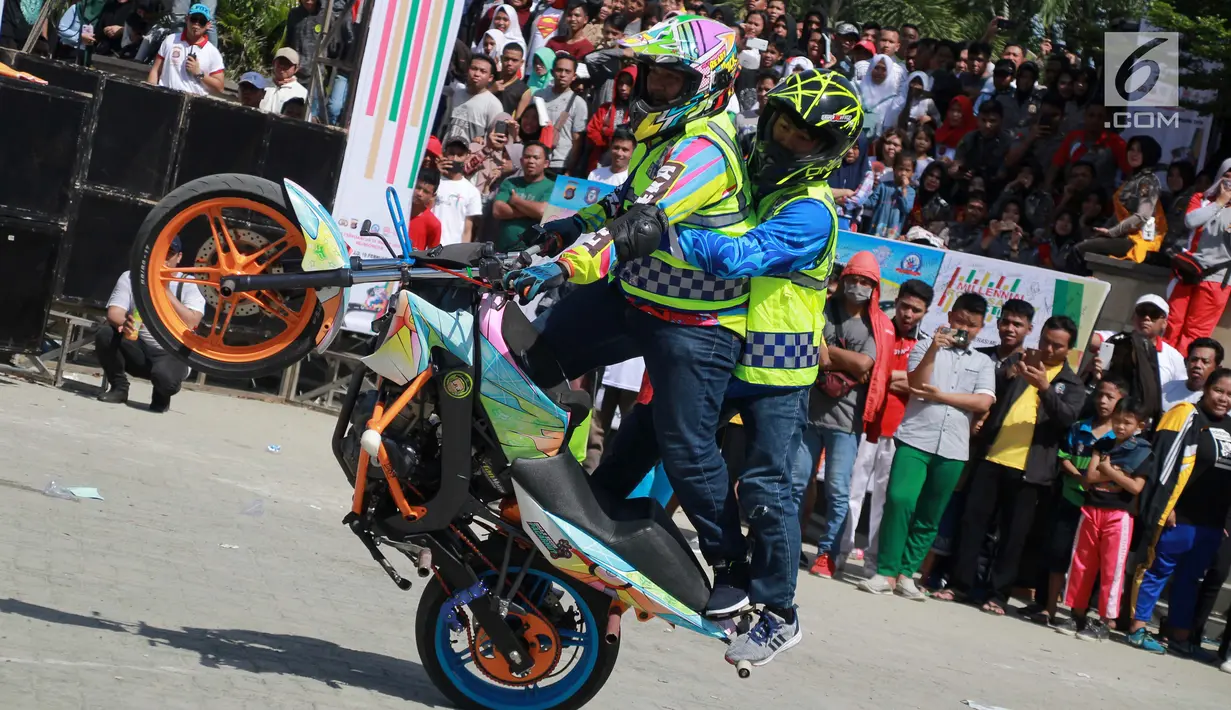 Aksi freestyle motor selama kegiatan Millenial Road Safety Festival Gorontalo, Minggu (10/2). Atraksi freestyle digelar di Lapangan Taruna Remaja Kota Gorontalo. (Liputan6.com/Rahmad Arfandi Ibrahim)