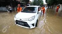 Petugas Damkar PB mendorong mobil terendam banjir di permukiman Bukit Duri, Jakarta, Kamis (16/2). Meluapnya Bendungan Katulampa, Bogor, menyebabkan permukiman kawasan Bukit Duri tergenang air dengan ketinggian 10 - 80 cm. (Liputan6.com/Helmi Afandi)