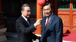 Menlu China, Wang Yi berbincang dengan Menko Kemaritiman, Luhut Pandjaitan sebelum pertemuan di Wisma Negara Diaoyutai, Beijing. Rabu (24/10). Pertemuan membahas kerja sama kedua negara antara lain di bidang kelauatan. (Daisuke Suzuki/Pool via AP)