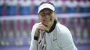 Senyum Maria Sharapova saat berpose dengan trofi setelah memenangkan pertandingan melawan Aryna Sabalenka di turnamen tenis Tianjin Open di Tianjin (15/10). Sharapova menang 7-5 7-6 atas Sabalenka. (AFP Photo/Wang Zhao)