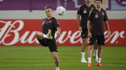 Bek Jerman, Joshua Kimmich menendang bola di samping Jonas Hofmann dan Niclas Fuellkrug saat sesi latihan di stadion Al-Shamal di Al-Ruwais, Qatar, Selasa, 29 November 2022. Jerman berada dalam posisi terdesak di klasemen grup dengan koleksi hanya satu poin dari 2 pertandingan hasil kalah atas Jepang dan imbang melawan Spanyol. (AP Photo/Matthias Schrader)