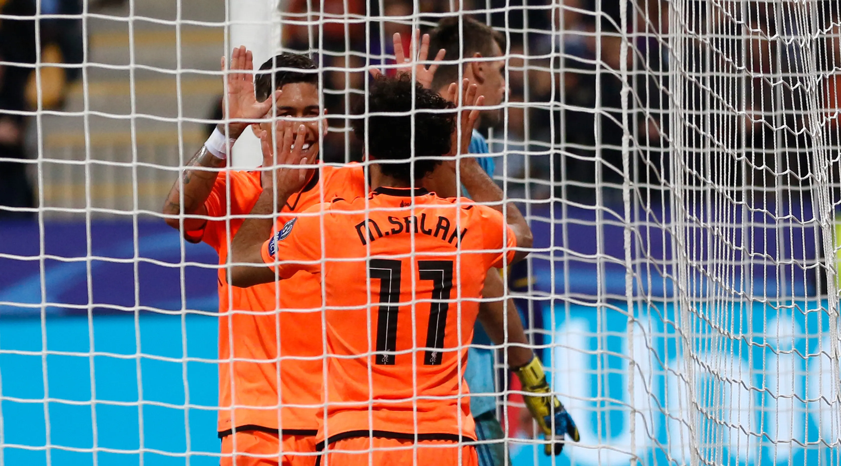 Mohamed Salah dan Roberto Firmino merayakan gol ke gawang Maribor pada matchday tiga Grup E Liga Champions. Liverpool unggul 7-0. (AP/Darko Bandic)