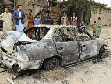 Penduduk setempat melihat kendaraan yang rusak akibat serangan roket di Kabul, Afghanistan, Senin (30/8/2021). Roket menghantam lingkungan dekat bandara internasional Kabul pada hari Senin di tengah penarikan AS yang sedang berlangsung dari Afghanistan. (AP Photo/Khwaja Tawfiq Sediqi)