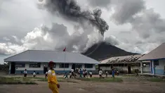 Sejumlah murid SD bermain di sekolah mereka saat erupsi Gunung Sinabung di Karo, Sumatera Barat (13/11). Meski erupsi, aktivitas kegiatan belajar di sekolah di Kabupaten Karo tersebut berjalan seperti biasa. (AFP Photo/Ivan Damanik)