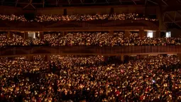 Ribuan jemaat yang hadir menyalakan lilin saat ibadah malam Natal berlangsung. (Juni KRISWANTO/AFP)