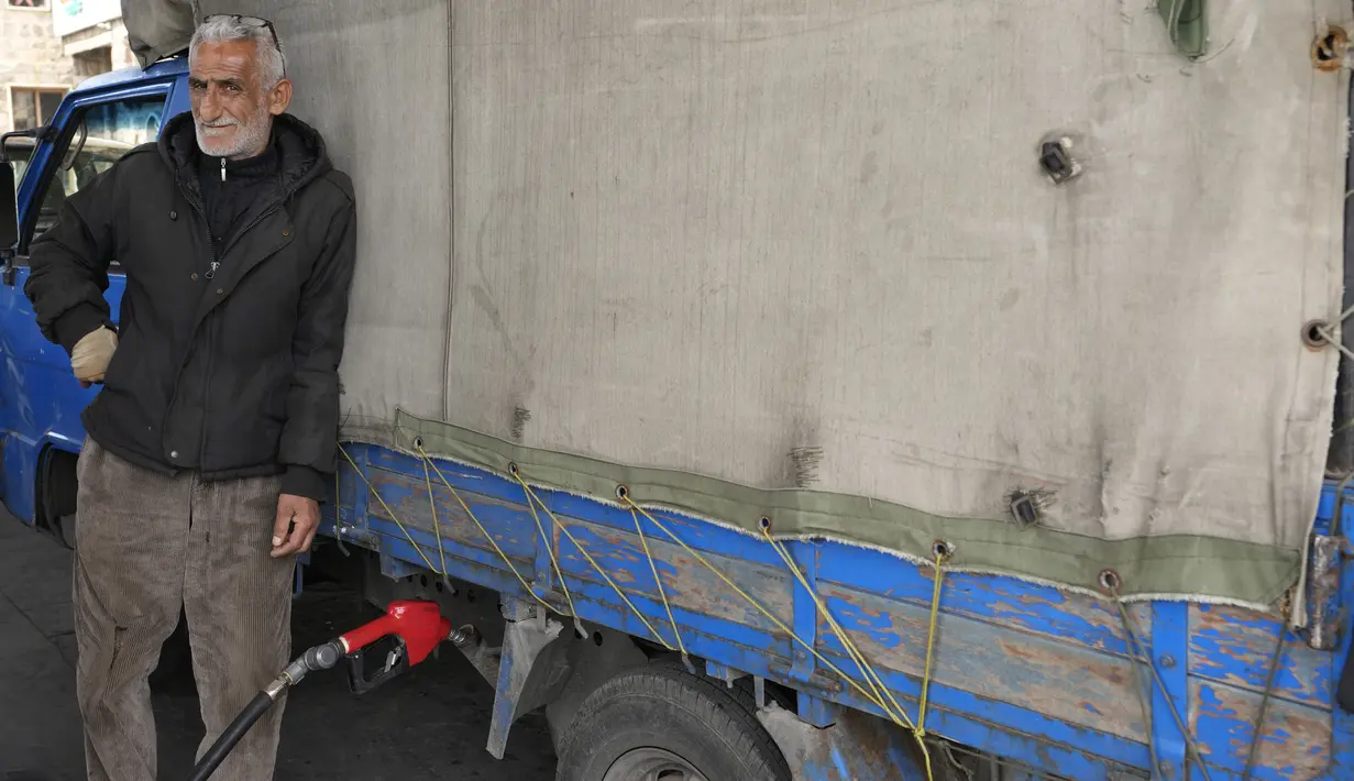 Seorang pria mengisi bahan bakar truknya di sebuah pompa bensin di Beirut, Lebanon, Senin (7/3/2022). Kenaikan harga minyak di seluruh dunia akibat dari invasi Rusia ke Ukraina menyebabkan antrean panjang kendaraan di pompa bensin selama krisis ekonomi terburuk Lebanon. (AP Photo/Hassan Ammar)