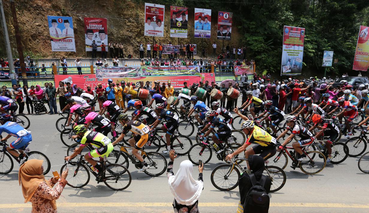 Para pebalap sepeda saat memulai start ulang di kota Painan dalam Etape 1 Tour de Singkarak 2015, Sabtu (3/10/2015). (Bola.com/Arief Bagus)
