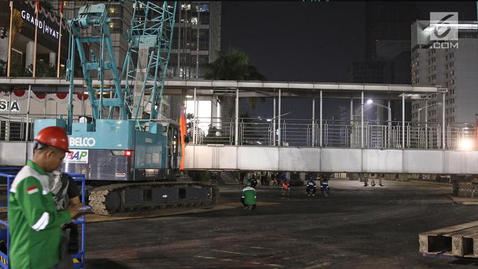 Petugas merobohkan Jembatan Penyeberangan Orang (JPO) di Kawasan Bundaran Hotel Indonesia, Jakarta, Senin (30/7) malam. Sehubungan dengan pembongkaran JPO itu, arus lalu lintas di seputaran Jalan MH Thamrin sempat ditutup. (Liputan6.com/Herman Zakharia)