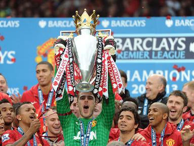 Kiper Manchester United, David de Gea mengangkat trofi Liga Inggris setelah memenangkan laga atas Swansea City di Old Trafford, Manchester, 12 Mei 2013. Ini merupakan satu-satunya trofi liga yang berhasil De Gea persembahkan selama 12 tahun membela Setan Merah. Kala itu, MU berhasil finis dengan raihan 89 poin atau unggul 11 poin dari sang rival sekota, Manchester City. (AFP/Andrew Yates)