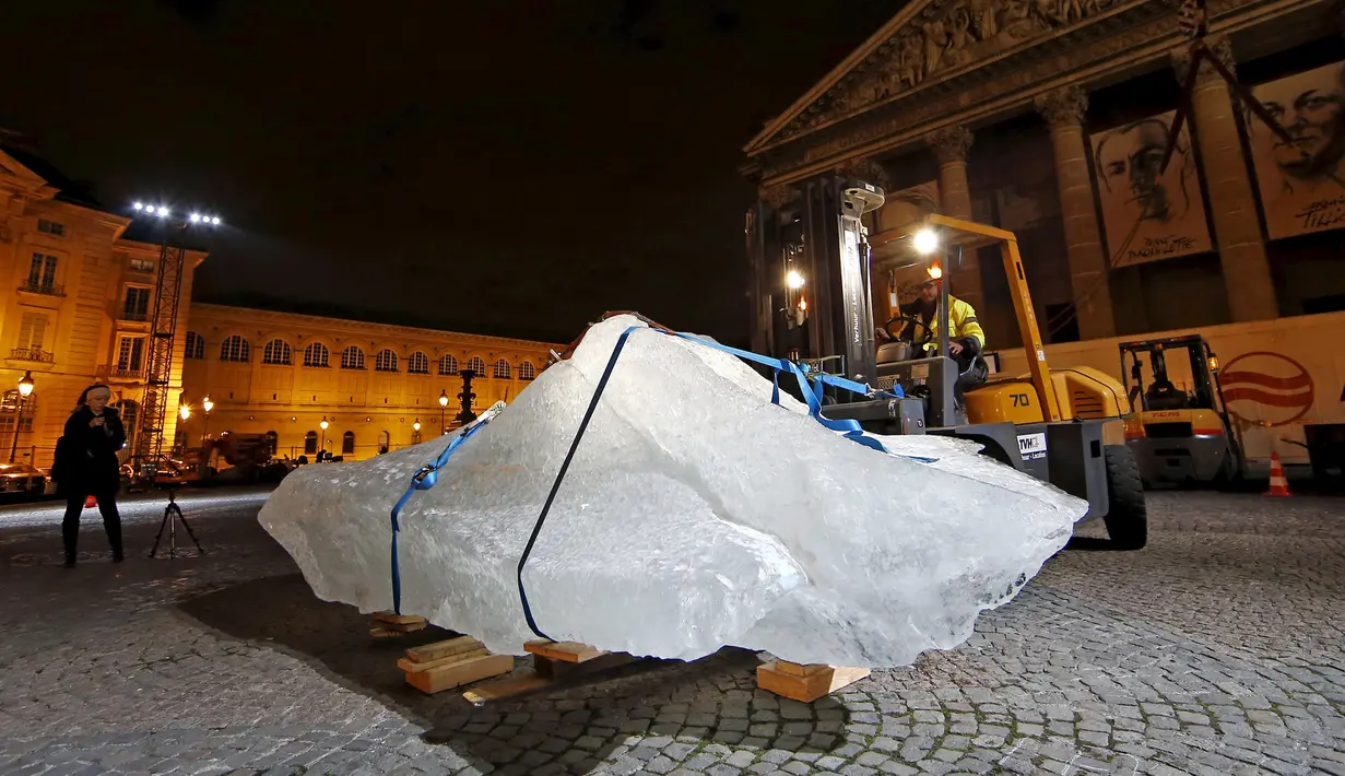 Petugas saat menurunkan balok es untuk diletakkan di Place du Pantheon Paris, Perancis, Kamis (3/12). Ini merupakan proyek pemerintah paris untuk membuat pertunjukan yang dinamakan Ice Watch Paris. (REUTERS/Benoit Tessier)