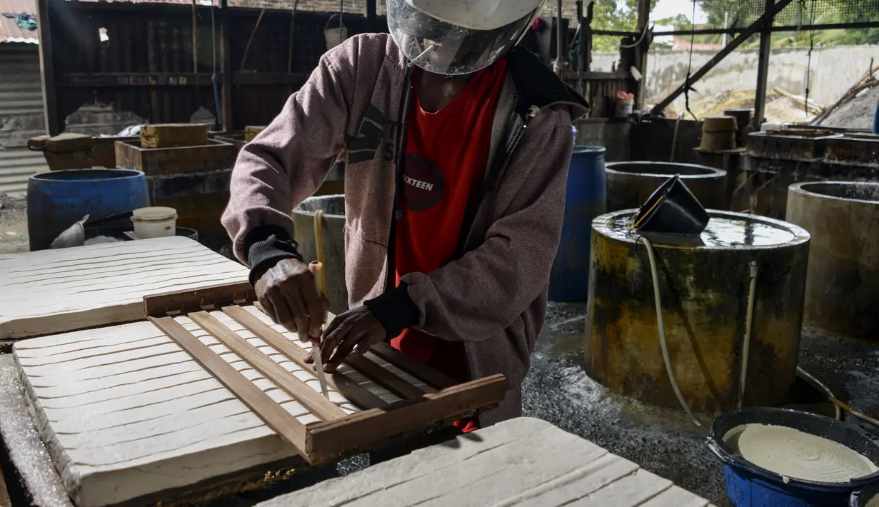 Seorang pekerja membuat tahu dari kedelai di sebuah fasilitas di Banda Aceh (12/10/2020). (AFP Photo/Chaideer Mahyuddin)