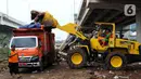 Petugas PPSU DKI Jakarta menggunakan alat berat saat mengangkut sampah sisa banjir di bawah Tol Becakayu, Cipinang Melayu, Jakarta Timur, Rabu (8/1/2020). Sampah sisa banjir tersebut selanjutnya diangkut ke TPA Bantar Gebang. (merdeka.com/Magang/Muhammad Fayyadh)