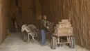 Pria bekerja di pabrik batu bata di pabrik batu bata di pinggiran tenggara Baghdad Nahrawan, Irak, Kamis (24/5/2021).  Para pekerja bekerja 12 jam sehari dengan upah sekitar USD$ 15. (AP Photo/Hadi Mizban)