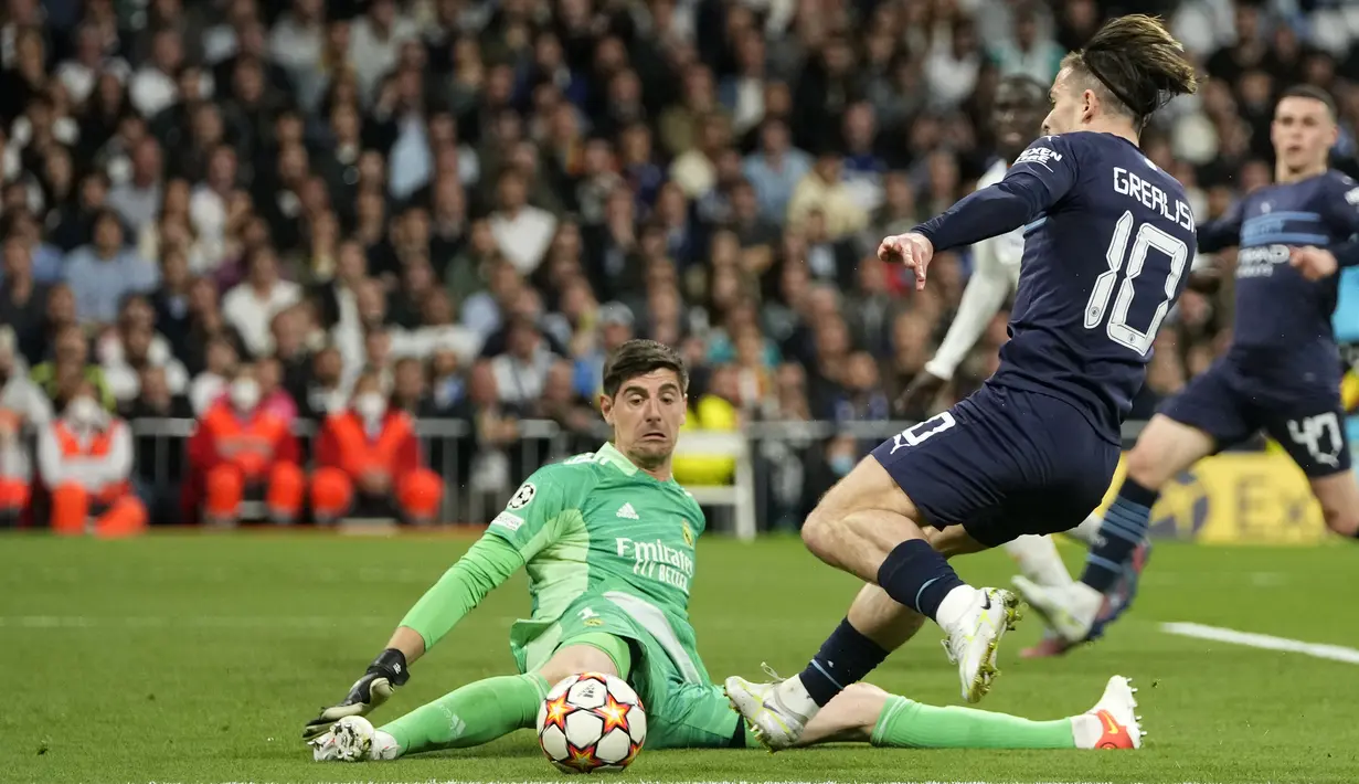 <p>Penjaga gawang Real Madrid Thibaut Courtois melakukan penyelamatan di depan Jack Grealish dari Manchester City selama pertandingan leg kedua semifinal Liga Champions di stadion Santiago Bernabeu, Spanyol, Kamis (5/5/2022). Madrid akan bertemu Liverpool pada babak final. (AP Foto/Manu Fernandez)</p>