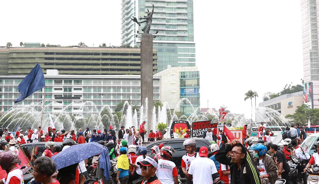 Massa pendukung pasangan calon presiden dan wakil presiden nomor urut 01 Jokowi-Ma'ruf Amin saat berkumpul di sekitar Bundaran HI, Jakarta, Sabtu (13/4). Ribuan orang berkumpul untuk menghadiri kampanye akbar pasangan Jokowi-Ma'ruf Amin di Stadion GBK. (Liputan6.com/Immanuel Antonius)