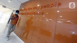 Agen FWD Insurance melintas di lobby kantor pemasaran baru di Soho Capital, Jakarta (21/11/2021). PT FWD Insurance Indonesia (FWD Insurance)  meresmikan kantor pemasaran baru untuk memperkuat posisinya dengan melakukan pendekatan asuransi jiwa yang lebih menyeluruh. (Liputan6.com/HO/FWD) 