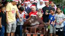 Orangutan bernama Pacquiao mengenakan topi Santa Claus saat merayakan pesta natal di Malabon, Filipina (21/12). Pacquiao bersama pendiri Malabon Zoo Manny Tangco ikut memeriahkan hari natal di Filipina. (AP Photo / Bullit Marquez)