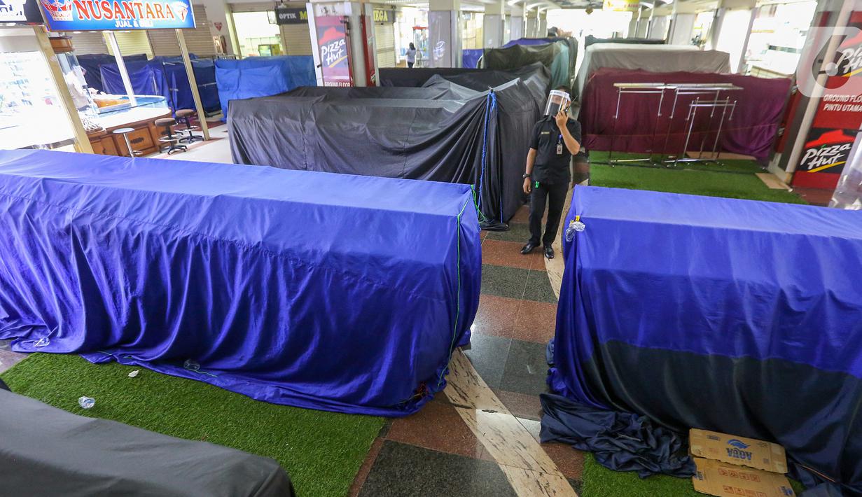 Petugas keamanan berkeliling di dalam kawasan pusat perbelanjaan ITC BSD Serpong, Tangerang Selatan, Selasa (16/6/2020). Sejumlah barang dagangan ditutup terpal selama PSBB Tangerang Raya diperpanjang hingga 28 Juni karena penambahan kasus positif Covid-19. (Liputan6.com/Fery Pradolo)