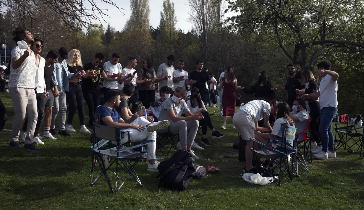 Orang-orang menari di sebuah taman di Ankara, sehari sebelum penerapan "penguncian penuh" atau lockdown, Rabu (28/4/2021). Turki akan memberlakukan lockdown penuh selama tiga minggu dari 29 April hingga 17 Mei 2021 untuk membendung penyebaran virus corona. (AP Photo/Burhan Ozbilici)