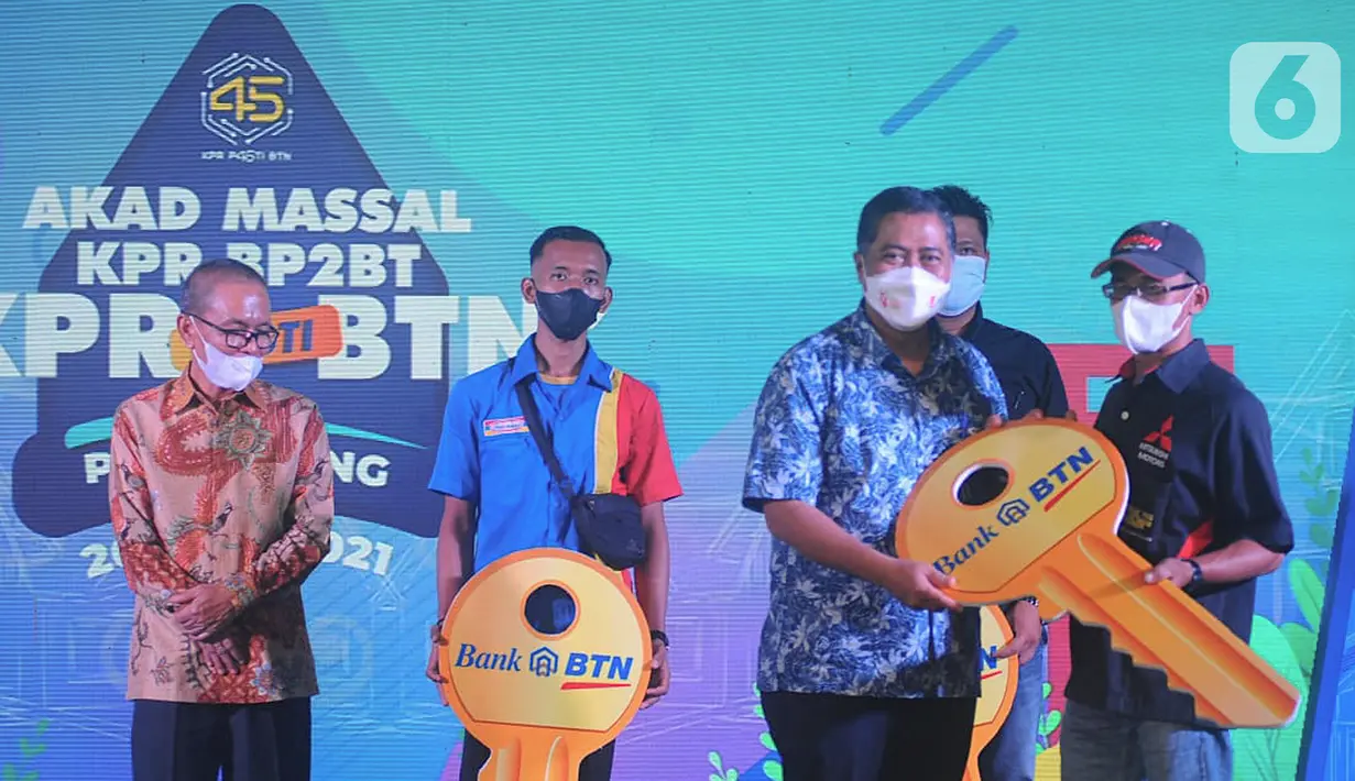 Direktur Consumer and Commercial Lending Bank BTN Hirwandi Gafar memberikan kunci rumah kepada konsumen pada Akad Kredit Massal KPR BP2BT di Perumahan Dream Land II, Palembang, Sumatera Selatan, Sabtu (20/11/2021). Akad massal ini meyukseskan program Pembangunan Sejuta Rumah. (Liputan6.com/HO/BTN)