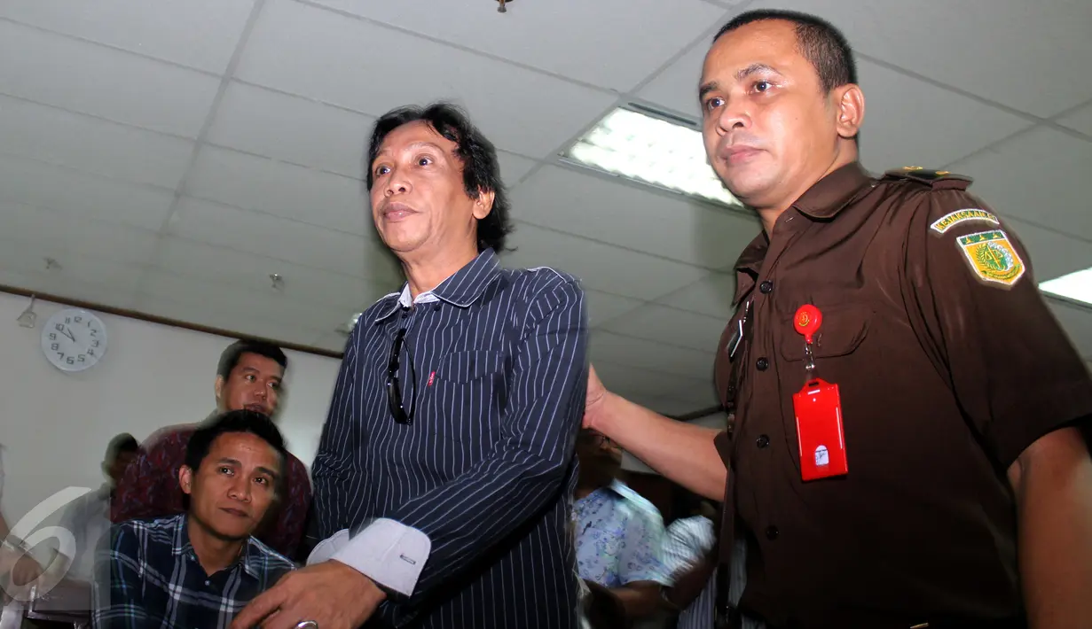 Komedian Mandra dikawal petugas usai menjalani sidang perdana beragenda pembacaan dakwaan di Pengadilan Tipikor, Jakarta, Kamis (20/8/2015). Mandra terjerat kasus korupsi pengadaan program siap siar TVRI pada 2012. (Liputan6.com/Yoppy Renato) 
