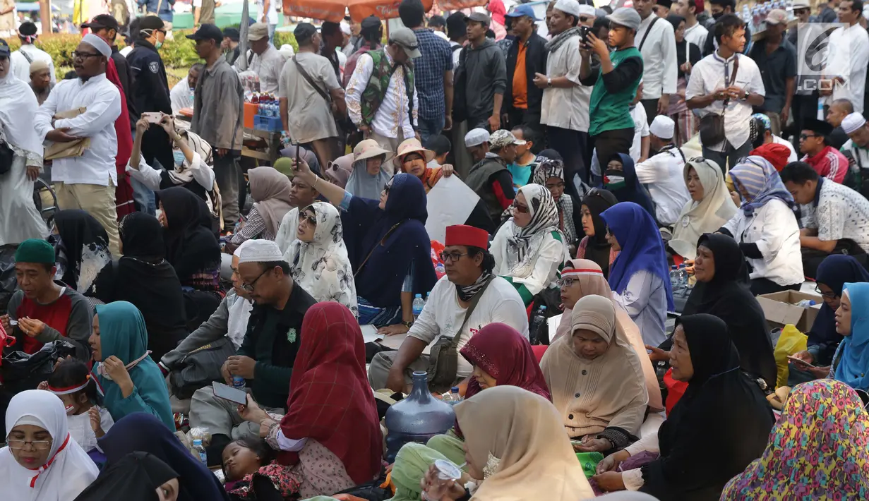 Massa aksi duduk istirahat di sekitaran Patung Kuda Arjuna Wiwaha di Jalan Medan Merdeka Barat, Jakarta, Kamis (27/6/2019). Massa aksi berkumpul terkait pelaksanaan sidang putusan perselisihan hasil Pilpres 2019 di Gedung Mahkamah Konstitusi. (Liputan6.com/Helmi Fithriansyah)