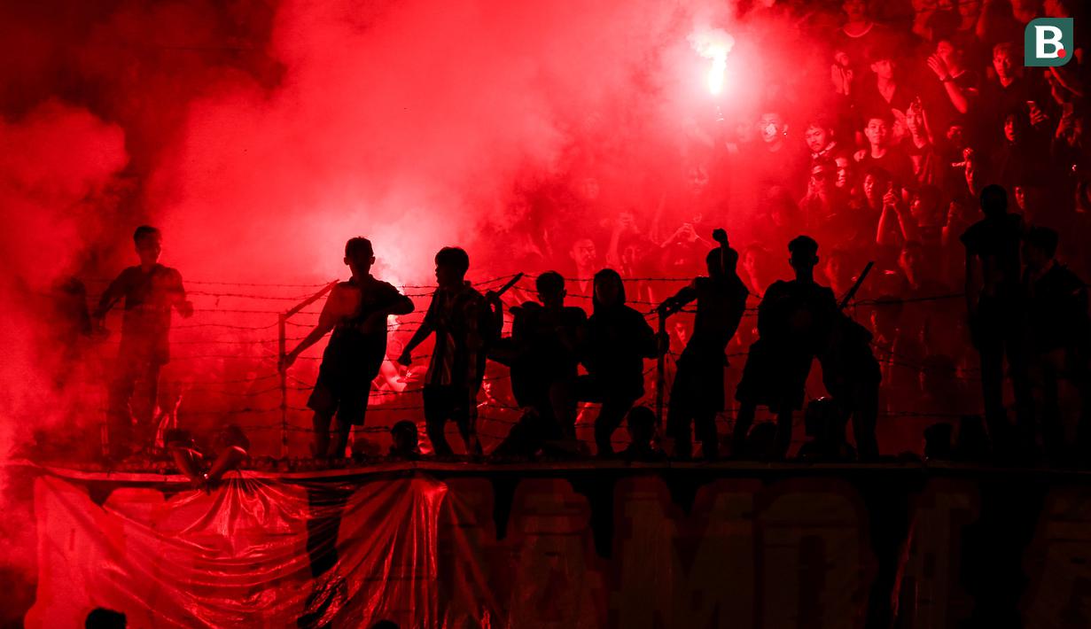 <p>Flare menyala di antara para pendukung Semen Padang saat laga leg kedua final Pegadaian Liga 2 2023/2024 antara Semen Padang mengadapi PSBS Biak di Stadion GOR Haji Agus Salim, Padang, Sabtu (9/3/2024). (Bola.com/Bagaskara Lazuardi)</p>