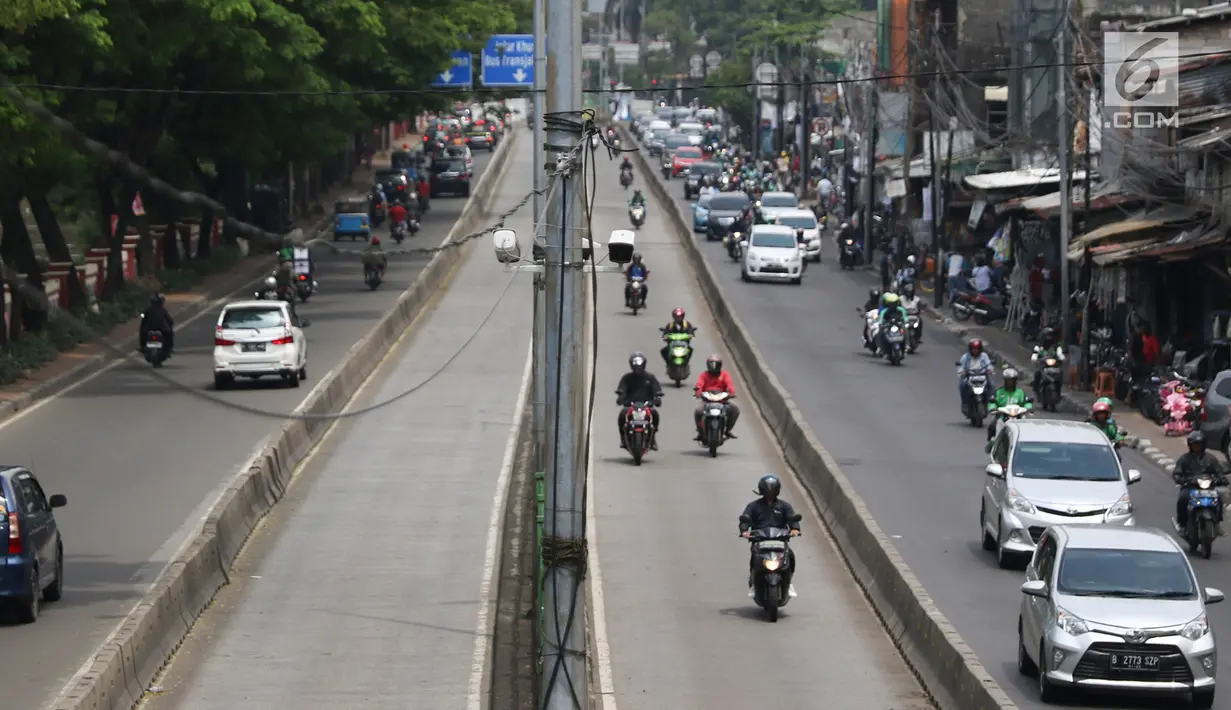 Pengendara motor melintasi jalur bus Transjakarta di kawasan Pasar Rumput, Jakarta, Rabu (20/2). Kamera pengawas atau CCTV akan dipasang di setiap halte Transjakarta yang terintegrasi dengan Ditlantas Polda Metro Jaya. (Liputan6.com/Immanuel Antonius)