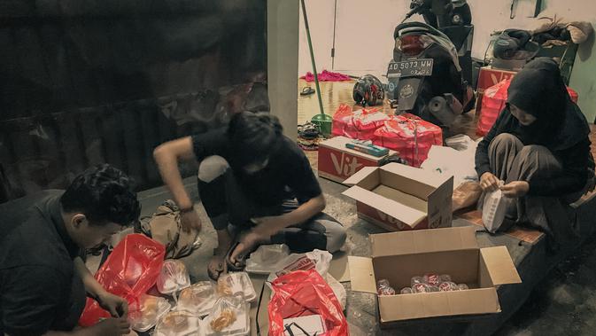 Relawan Positive Vibes sedang mengemas nasi bungkus. (Dok. Positive Vibes)