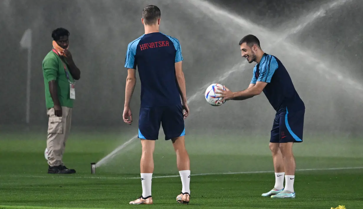 Bek Kroasia Josip Juranovic (kanan) mengikuti sesi latihan di tempat latihan Al Erssal, Doha, Qatar, Rabu (30/11/2022). Saat ini Kroasia berada didekat garis finish menuju 16 besar dengan menduduki dua peringkat teratas grup F bersama Maroko. (OZAN KOSE/AFP)