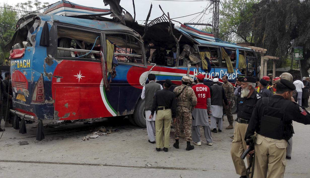 Petugas melakukan pemeriksaan kondisi bus rombongan pegawai Pakistan usai diserang bom di Peshawar, Pakistan, Rabu (16/3). Bus yang membawa rombongan pegawai pemerintah ini menewaskan setidaknya 10 orang dan 27 lainnya terluka. (REUTERS/Fayaz Aziz)