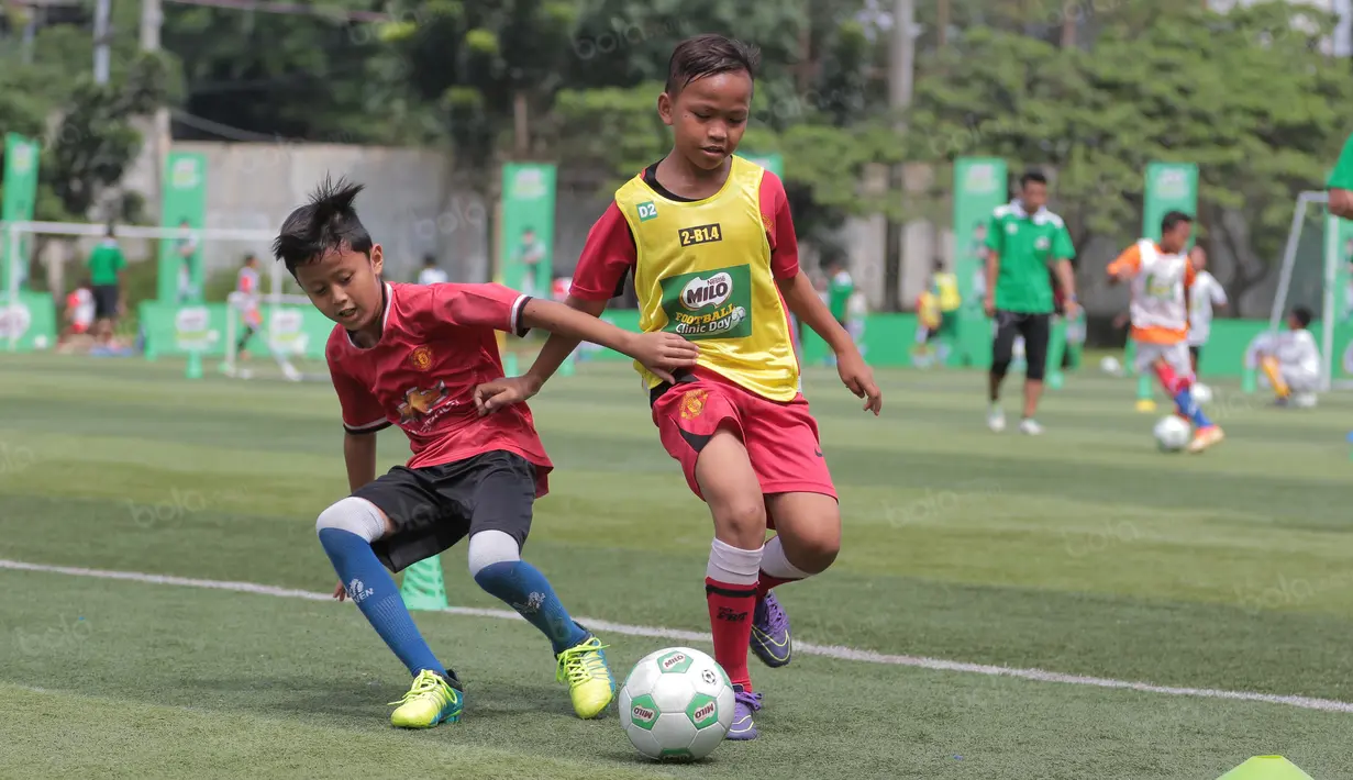 Aksi dua siswa  berebut bola saat mengikuti ajang Milo Football Clinic Day, Minggu (30/10/2016) di Simprug. (Bola.com/Nicklas Hanoatubun)