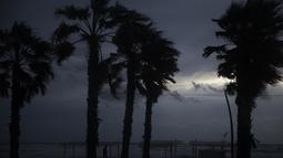 Seseorang berjalan di sepanjang tepi pantai Laut Mediterania saat angin kencang dan ombak menerjang saat cuaca badai di Hadera, Israel, Senin (20/12/2021). Badai musim dingin melintasi Mediterania timur menghantam garis pantai Israel dengan hujan dan angin kencang. (AP Photo/Ariel Schalit)