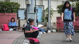 Sejumlah Mahasiswa IKJ Fakultas Seni Rupa duduk dipinggir jalan melukis suasana Bundaran HI, Jakarta Pusat, Kamis (19/10). Mereka melukis suasana Bundaran HI untuk mengaplikasikan ilmu yang didapatnya saat kuliah. (Liputan6.com/Faizal Fanani)