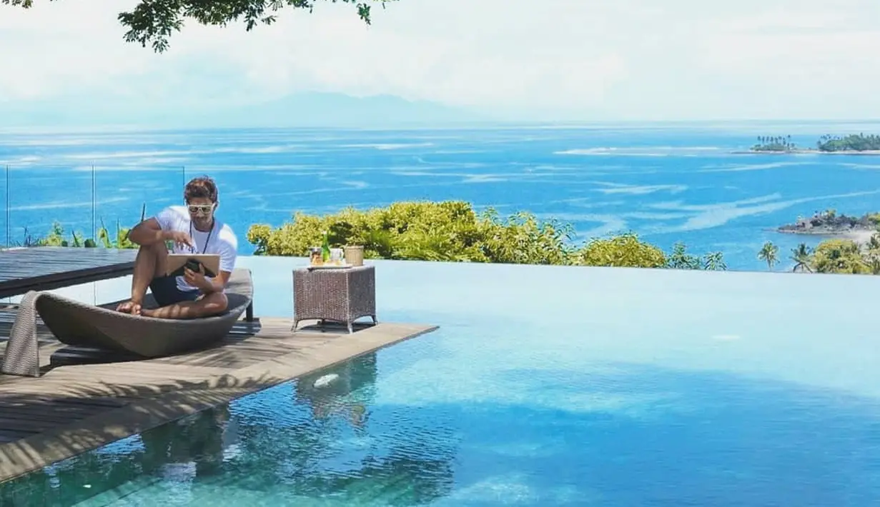 Kali ini Ammar terlihat berada di tepi kolam renang yang bersebelahan dengan hamparan laut luas sepertinya. Rona bahagia terpancar dari pemeran sinetron Anak Langit ini. (Instagram/ammarzoni)