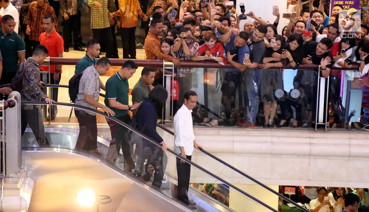 Presiden Joko Widodo menyapa warga ketika tiba di Sun Plaza Medan, Sumatera Utara, Jumat (24/11). Jokowi tiba mengenakan kemeja putih lengan panjang dan celana hitamnya sambil menebar senyum. (Liputan6.com/Johan Tallo)