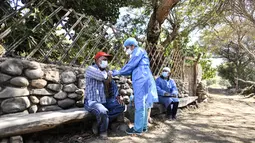 Petugas kesehatan menyuntikkan vaksin Covid-19 kepada warga di desa pedalaman di Arequipa, Peru (2/7/2021). Peru menggencarkan vaksinasi warga lanjut usia dengan vaksin Pfizer-BioNTech sebagai upaya untuk mengatasi pencegahan pandemi Covid-19. (AFP/Diego Ramos)