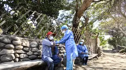 Petugas kesehatan menyuntikkan vaksin Covid-19 kepada warga di desa pedalaman di Arequipa, Peru (2/7/2021). Peru menggencarkan vaksinasi warga lanjut usia dengan vaksin Pfizer-BioNTech sebagai upaya untuk mengatasi pencegahan pandemi Covid-19. (AFP/Diego Ramos)