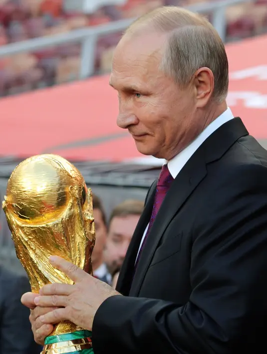 Presiden Rusia Vladimir Putin membawa trofi Piala Dunia FIFA di Stadion Luzhniki, Moskow (9/9). Piala Dunia 2018 akan dimulai di stadion Luzhniki pada 14 Juni 2018. (Mikhail Klimentyev, Sputnik, Kremlin Pool Photo via AP)