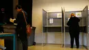 Pemilih memasukkan surat suara ke kotak suara saat pemilihan umum Belanda di sebuah Tempat Pemungutan Suara (TPS) di Den Haag, Rabu (15/3). Ada yang unik dalam pemilu Belanda itu, dimana tempat sampah disulap menjadi kotak suara. (AP Photo/Peter Dejong)