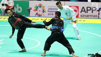 Pesilat Indonesia, Komang Harik Adiputra (kanan) bertanding melawan pesilat Timor Leste, David No-Ano Ximenes dalam kelas 65-70 kg Putra Asian Games 2018 di Padepokan Pencak Silat TMII, Jakarta, Kamis (23/8). Komang unggul 5-0. (Liputan6.com/Fery Pradolo)