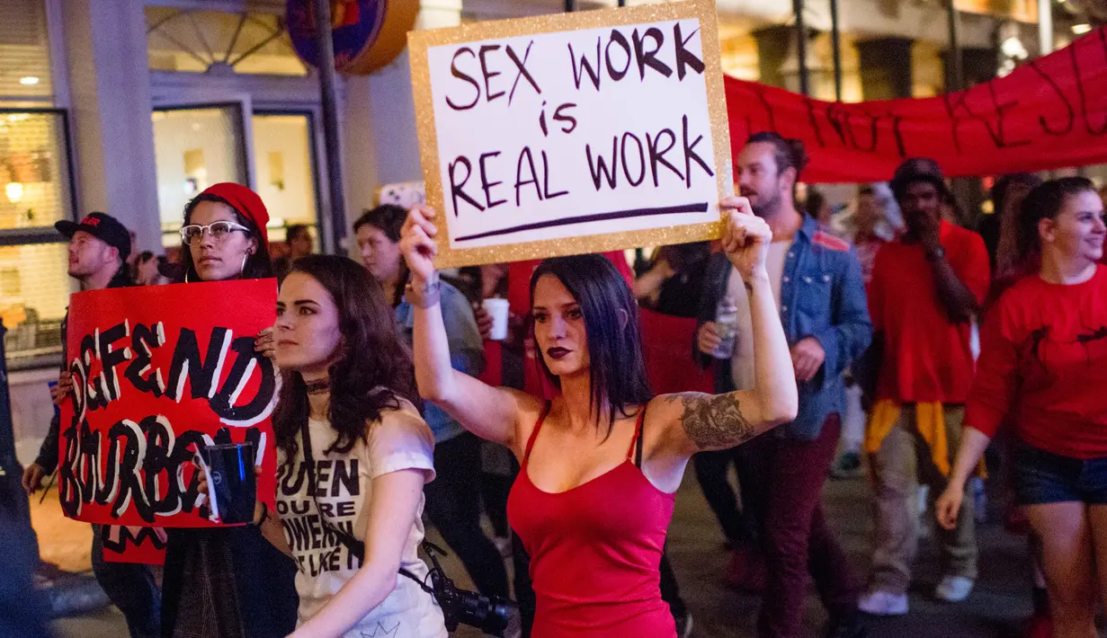 Sejumlah orang membawa poster saat melakukan demonstrasi di Bourbon Street, New Orleans (1/2). Mereka melakukan aksi terkait penggerebekan polisi dan penutupan sejumlah klub malam. (AFP/Emily Kask)