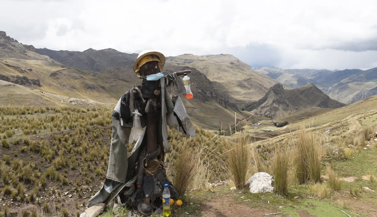Orang-orangan sawah berpakaian seperti penambang berdiri di dekat kantor bekas tambang yang tutup pada dekade terakhir abad XX di kota hantu Santa Barbara, Peru, Kamis (2/12/2021). (AP Photo/Franklin Briceño)